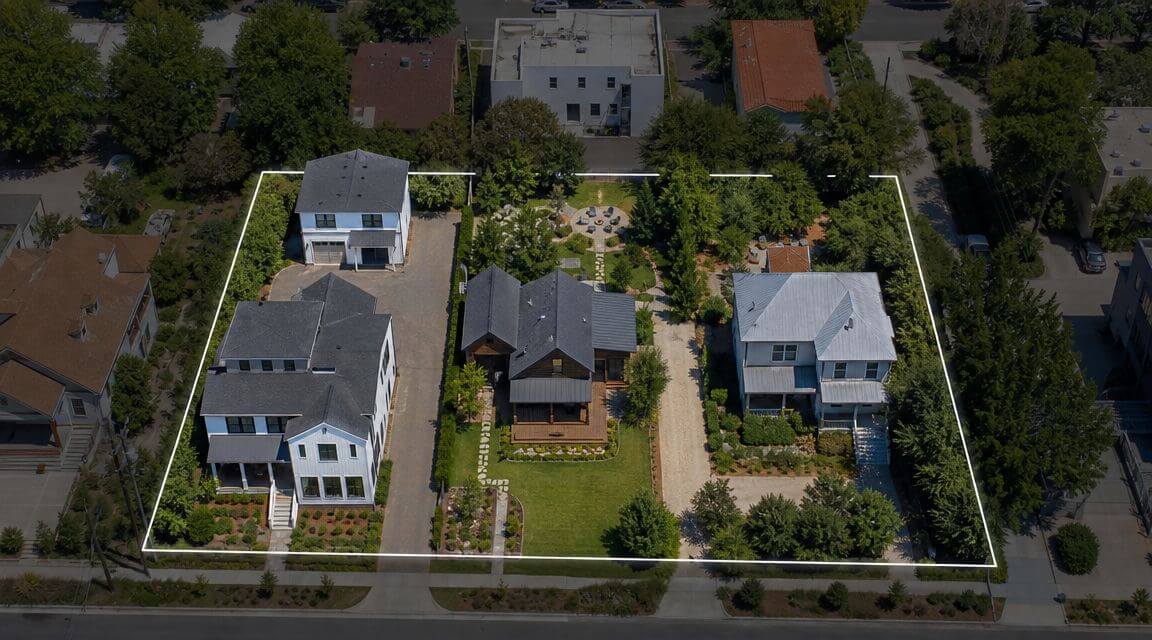 Certificados Energéticos | Parcela construida Sin división horizontal Vista aérea de una parcela con varias casas rodeadas de jardines y zonas verdes bien cuidadas.