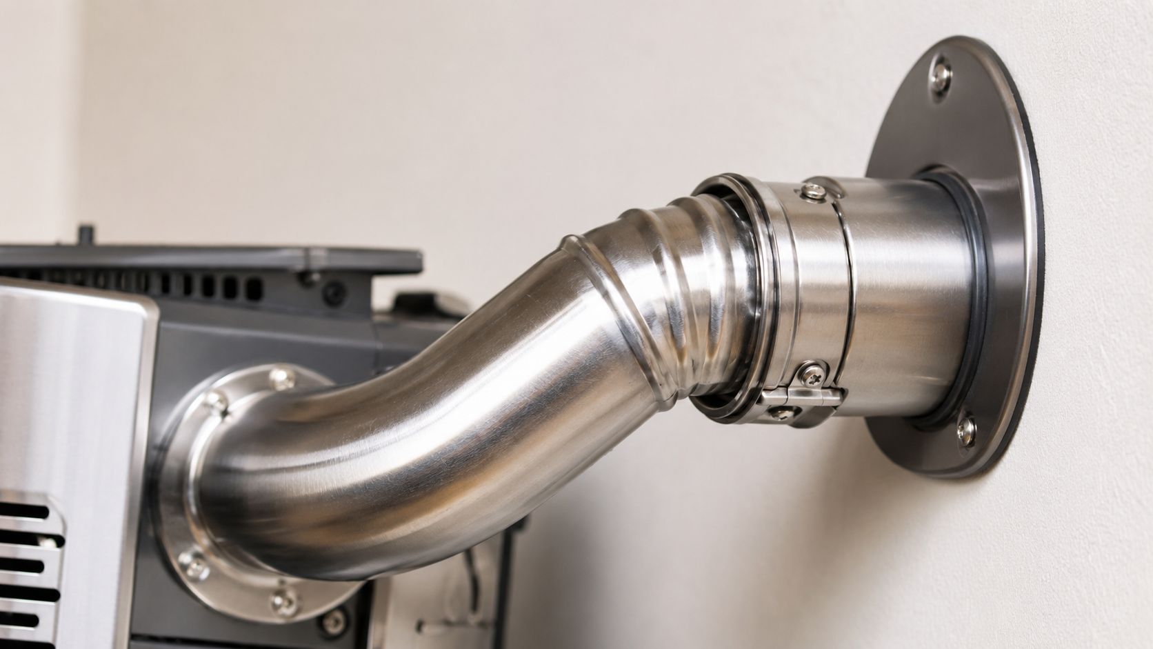 Certificados Energéticos | Normativa salida gases Calentador Butano Tubería de acero inoxidable conectada a un calentador de gas que atraviesa una pared blanca